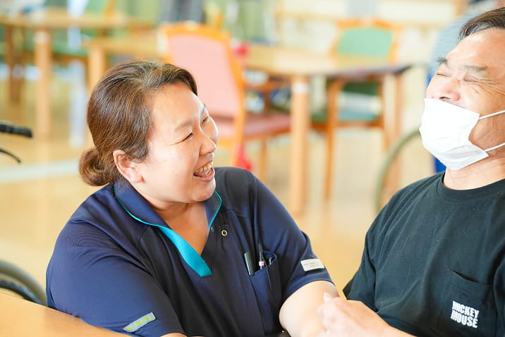 利用者とスタッフが笑顔で交流する温かい介護サービスの様子