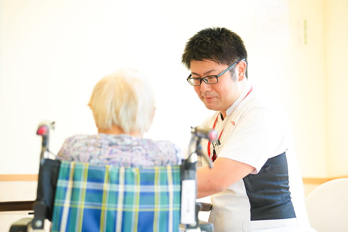 男性スタッフが笑顔で介助をしています